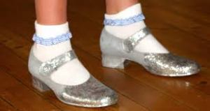 The Oz series talk of silver not ruby slippers, (which show up better on film.)